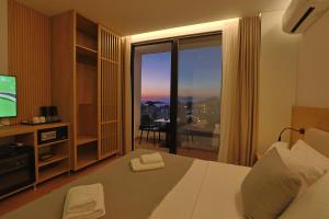 a hotel room with a bed and a large window at Hotel Danedi in Ksamil