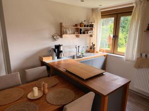 a kitchen with a wooden table and a sink at Bisamlodge in Faßberg