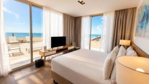 a hotel room with a bed and a view of the ocean at Pinamar Beach Resort in Pinamar