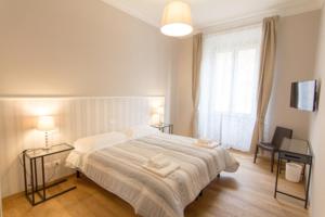 a bedroom with a large bed with two tables and a window at Cittadella 5 in Florence