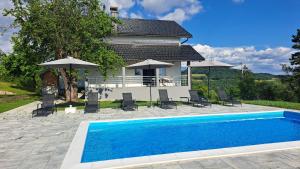 a villa with a swimming pool in front of a house at Villa Sunset in Banja Luka