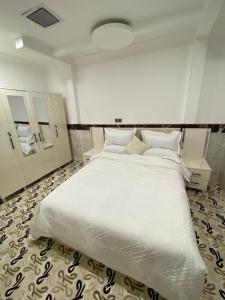 a bedroom with a large bed with white sheets and pillows at Bani motel in Duhok