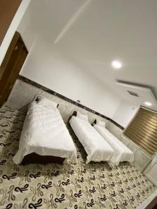 a room with three beds with white pillows at Bani motel in Duhok