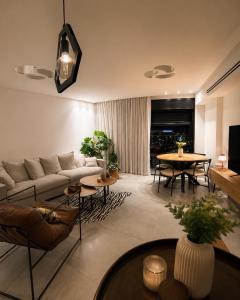 a living room with a couch and tables at amor premium residence-4BR apartment with balcony in Beer Sheva +7 photos