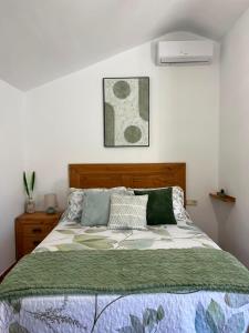 a bedroom with a bed with a green comforter at Aldeana Rural in El Cubillo