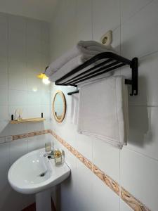 a white bathroom with a sink and a mirror at Aldeana Rural in El Cubillo