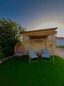 two chairs and a gazebo on a lawn at Aldeana Rural in El Cubillo
