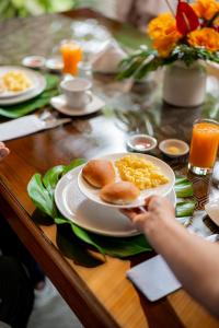 a person holding a plate of breakfast food on a table at Muyuterra in Moyobamba