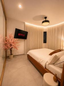a bedroom with a bed and a television in it at amor premium residence-4BR apartment with balcony in Beer Sheva