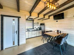 a kitchen and dining room with a wooden wall at Будиночки Ґалєрія in Vaydry
