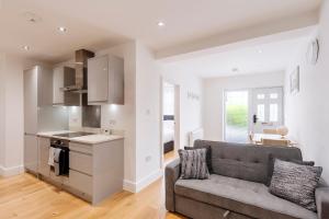 a living room with a couch and a kitchen at Sunnymede Court in Billericay