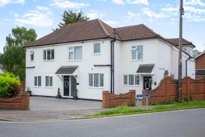 a white house with a brown roof at Sunnymede Court in Billericay