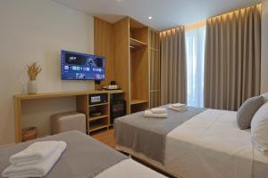 a hotel room with a bed and a flat screen tv at Hotel Danedi in Ksamil +83 photos