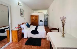 a bedroom with a bed with a black cat on it at Praia do Sol in Tarrafal