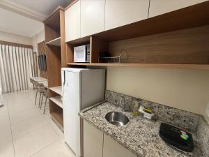 a small kitchen with a sink and a refrigerator at Spazzio diRoma Caldas Novas in Caldas Novas