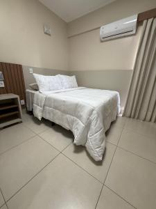 a bedroom with a bed with a white comforter at Spazzio diRoma Caldas Novas in Caldas Novas +42 photos