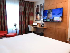 ein Hotelzimmer mit Bett und Flachbildfernseher in der Unterkunft Movenpick Hotel Ankara in Ankara
