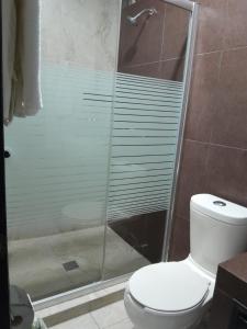 a bathroom with a glass shower with a toilet at Hotel Visión in Tuxpan de Rodríguez Cano