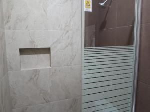 a bathroom with a shower with a stone wall at Hotel Visión in Tuxpan de Rodríguez Cano