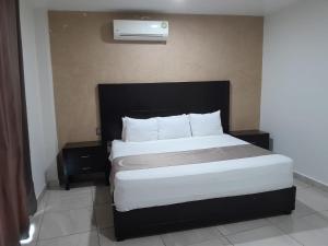 a bedroom with a large bed with a black headboard at Hotel Visión in Tuxpan de Rodríguez Cano