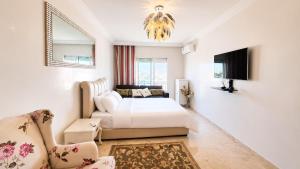 a white bedroom with a bed and a couch at Central luxury apart Mohammedia in Mohammedia