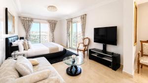 a hotel room with a bed and a couch and a tv at Central luxury apart Mohammedia in Mohammedia