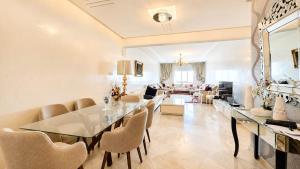 a large living room with a table and chairs at Central luxury apart Mohammedia in Mohammedia