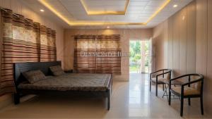 a room with a bed and two chairs in it at Diamond Hills Resort in Battakundi