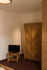 a room with a television and a wooden cabinet at Pension Glück in Schleife +9 photos
