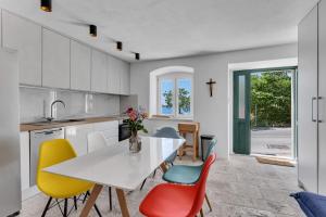 a kitchen with a white table and colorful chairs at Holiday Home Pelegrin in Brela