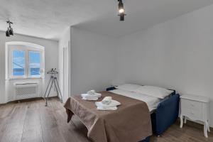 a bedroom with a bed with towels on a table at Holiday Home Pelegrin in Brela