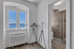 a white bathroom with a shower and a telescope at Holiday Home Pelegrin in Brela