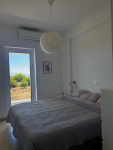 a bedroom with a bed and a large window at Villa Peony Koroni in Koroni +68 photos