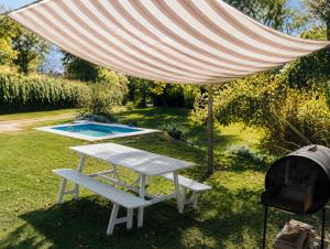 a picnic table and a grill under a large umbrella at Casa Verde in La Cumbre