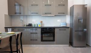 a kitchen with stainless steel appliances and a table at Celivine Seaside Residence in Faliraki +10 photos