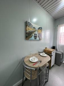 a room with a table with chairs and a painting on the wall at Hospedaje Oasis Modulares in Calama