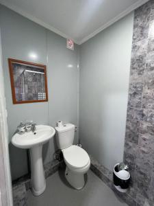 a bathroom with a toilet and a sink at Hospedaje Oasis Modulares in Calama +88 photos