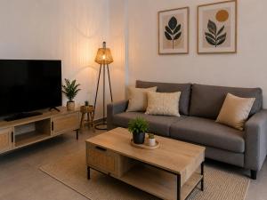 a living room with a couch and a tv at Celivine Seaside Residence in Faliraki