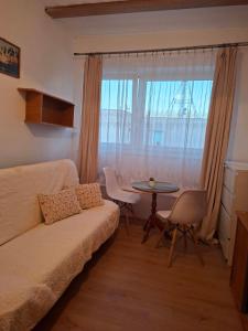 a living room with a couch and a table and a window at Dom Wczasowy Jędrek pokoje in Niechorze