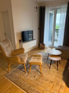 a living room with a chair and a table at Ribica Apartments in Ilidža