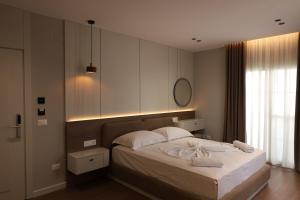 a bedroom with a bed with two towels on it at Olivia Hotel in Durrës