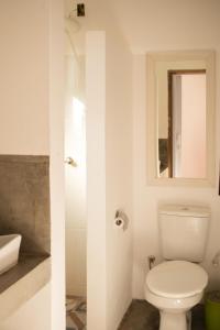 a bathroom with a toilet and a sink and a mirror at Casa Jasmim in Marau