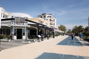 a street with buildings and people walking down the street at Olivia Hotel in Durrës