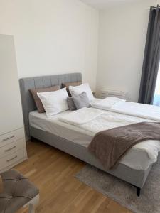 a bedroom with a large bed with white sheets and pillows at Ribica Apartments in Ilidža