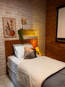 a bedroom with a bed and a blank screen at Vila do Sossego in São Bento do Sapucaí
