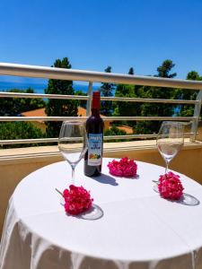a bottle of wine sitting on a table with two glasses at Hotel Neptun Gradac in Gradac