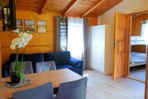 a living room with a table and a blue couch at Domki Anetta in Dąbki +13 photos
