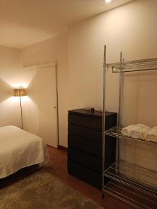 a bedroom with a bed and a shelf with towels at Villa Régio Studio in Vila do Conde
