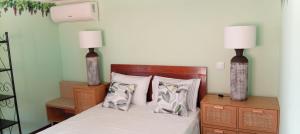 a bedroom with a bed with two lamps on it at Retiro dos Cedros - Quarto Vinhas in Fogueira