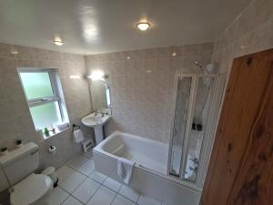 a bathroom with a tub and a toilet and a sink at Derryhick Escape in Crillaun +24 photos
